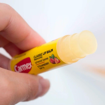 Carmex Daily Care Moisturizing Lip Balm Stick in Strawberry flavor with SPF 15, 4.25g, shown with a red and white cap.
